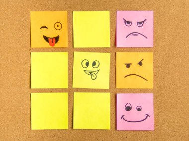 sticky note with a funny smiley face on cork board, with copy space