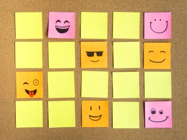 sticky note with a funny smiley face on cork board, with copy space