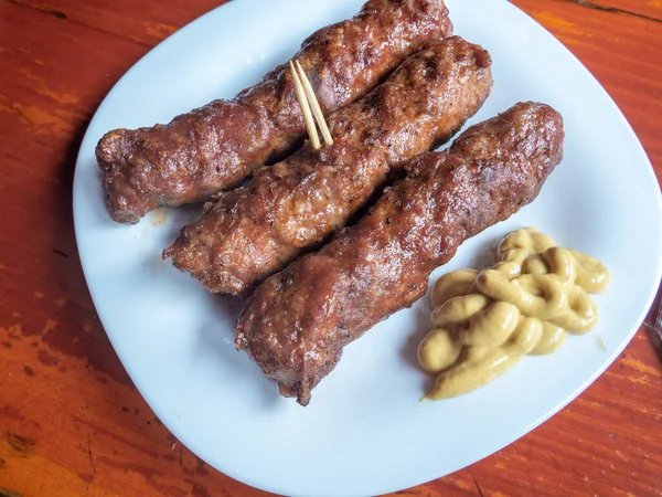 Skinless meat roll sausage or mici traditional balkan romanian ottoman cuisine delicacy served with mustard