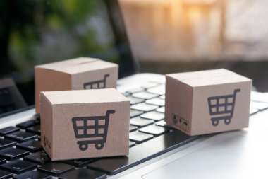 İnternetten alışveriş, kağıt kutular ya da klavyede alışveriş arabası logosu olan bir paket. İnternet üzerinden alışveriş hizmeti sunuyor.