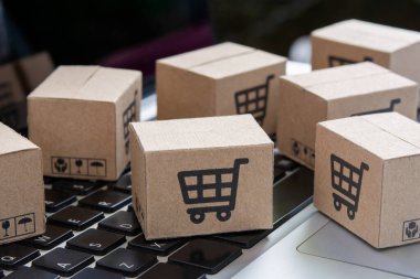 İnternetten alışveriş, kağıt kutular ya da klavyede alışveriş arabası logosu olan bir paket. İnternet üzerinden alışveriş hizmeti sunuyor.