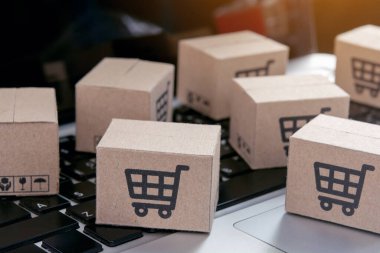 İnternetten alışveriş, kağıt kutular ya da klavyede alışveriş arabası logosu olan bir paket. İnternet üzerinden alışveriş hizmeti sunuyor.