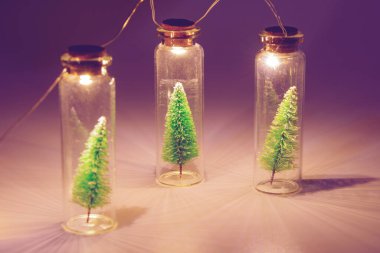 Mutlu Noeller ve yeni yıl konsepti, ampul ve cam kavanozdaki küçük Noel ağacı.