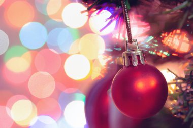 Noel süsü. Çam dallarında asılı kırmızı toplar Noel ağacı çelengi ve soyut bokeh arka planında fotokopi ile süslenmiş süsler.