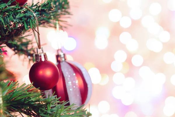 Noel süsü. Çam dallarında asılı kırmızı toplar Noel ağacı çelengi ve soyut bokeh arka planında fotokopi ile süslenmiş süsler.