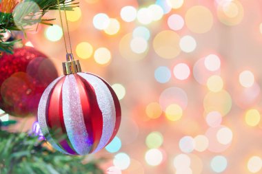 Noel süsü. Çam dallarında asılı kırmızı toplar Noel ağacı çelengi ve soyut bokeh arkaplanının üzerinde fotokopi alanı olan süsler