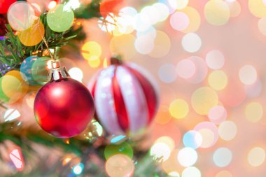 Noel süsü. Çam dallarında asılı kırmızı toplar Noel ağacı çelengi ve soyut bokeh arkaplanının üzerinde fotokopi alanı olan süsler