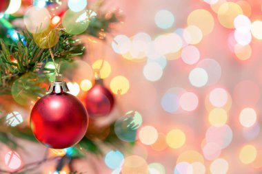 Noel süsü. Çam dallarında asılı kırmızı toplar Noel ağacı çelengi ve soyut bokeh arkaplanının üzerinde fotokopi alanı olan süsler