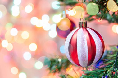 Noel süsü. Çam dallarında asılı kırmızı toplar Noel ağacı çelengi ve soyut bokeh arkaplanının üzerinde fotokopi alanı olan süsler