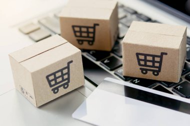 İnternetten alışveriş. Kredi kartı ve klavyede alışveriş arabasının logosu olan karton kutu. İnternet 'te alışveriş servisi. Eve teslimat teklif ediyor