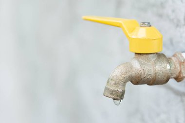 Musluk ve su damlası. Eski sarı musluk 