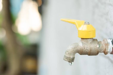 Musluk ve su damlası. Eski sarı musluk 