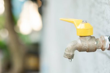 Musluk ve su damlası. Eski sarı musluk 