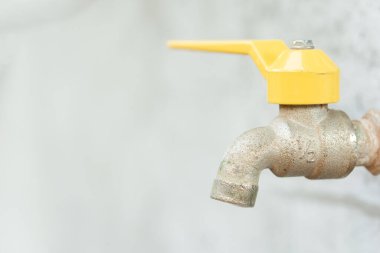 Musluk ve su damlası. Eski sarı musluk 