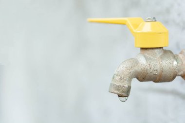 Musluk ve su damlası. Eski sarı musluk 