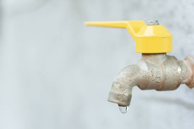 Musluk ve su damlası. Eski sarı musluk 