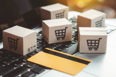 İnternetten alışveriş. Kredi kartı ve klavyede alışveriş arabasının logosu olan karton kutu. İnternet 'te alışveriş servisi. Eve teslimat teklif ediyor