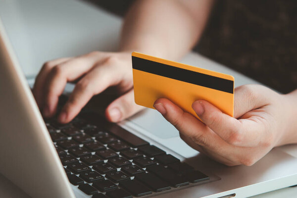 Credit card payment. Woman hands holding credit card and using laptop. Online shopping