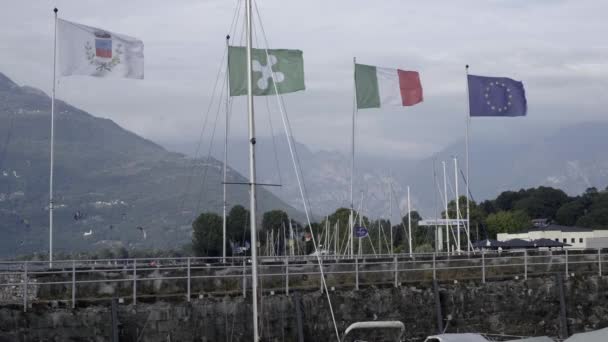 Ιταλική και ευρωπαϊκή σημαία κυματίζει στην αποβάθρα της λίμνης Κόμο, Ιταλία — Αρχείο Βίντεο