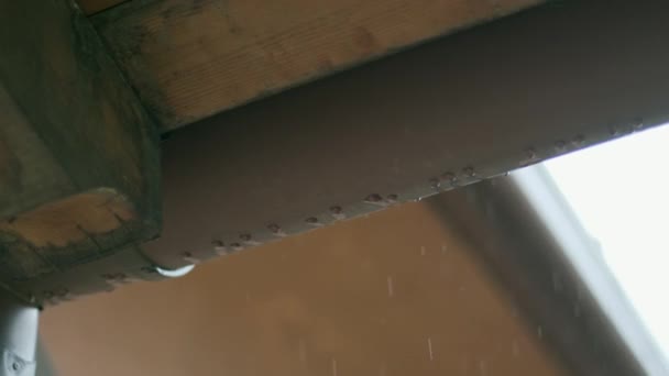SLOMO: stromend regenwater van het dak van het huis — Stockvideo