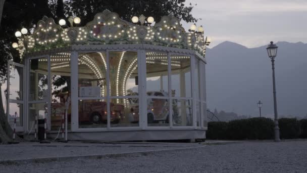 ロングショット:日没時にイタリアのメリーゴーラウンドカロセルを回転 — ストック動画