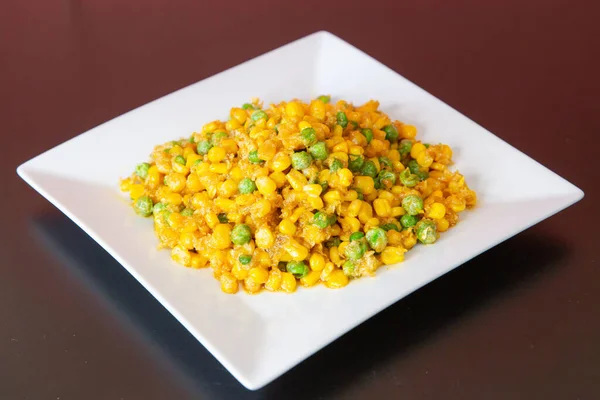 Salted egg sweet corn of traditional Cantonese yum-cha Asian gourmet cuisine meal food dish on the white serving plate and brown red table