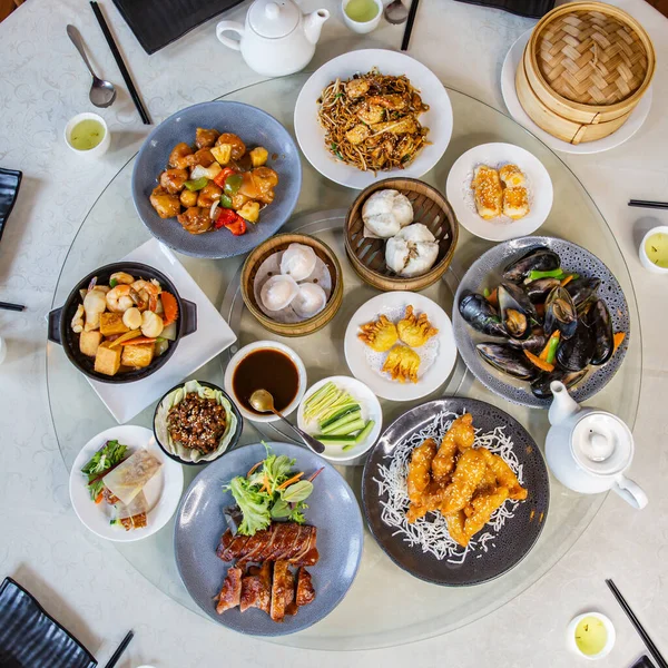 Top view food platter combo set of traditional Cantonese yum-cha dim sum Asian gourmet cuisine meal food dish on the round table includes dishes of duck, pork, fish, chicken, vegetables, tea