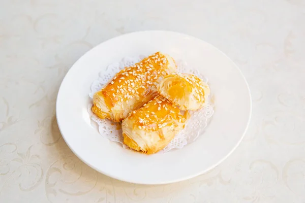 Egg yolk pastry puff cake dim sum of traditional Cantonese yum-cha Asian gourmet cuisine meal food dish on the white serving plate and white table