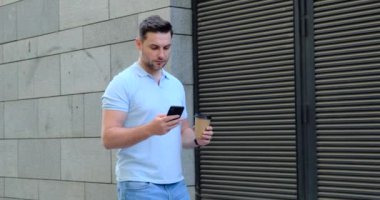 Kahveli gülümseyen adam ofisin yakınında cep telefonuyla konuşuyor. Güzel gün