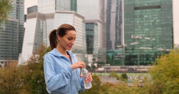 Ritratto di donna attiva che beve dalla bottiglia d'acqua mentre riposa dalla formazione — Video Stock