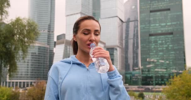 Portrét aktivní ženy pijící z láhve s vodou při odpočinku z tréninku — Stock video