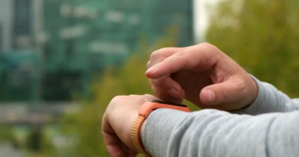 Фитнес-человек смотреть на умный часы на открытом воздухе спортсмен тренировки оборудования веревка приложение — стоковое видео