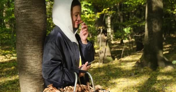 Wolna kobieta oddycha czystym powietrzem w lesie natury. dziewczyna z koszem grzybów — Wideo stockowe
