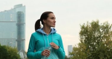 Central Park 'ta antrenman yaparken spor şişesinden içen fitness kızı.