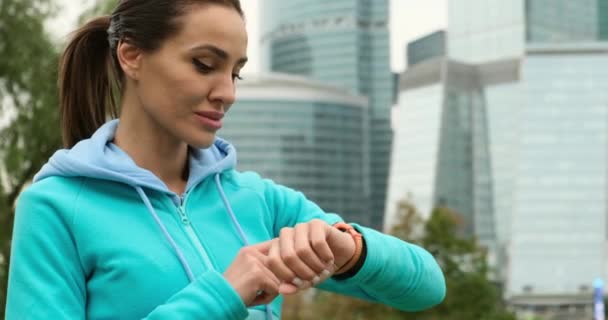 Atletische vrouw zet fitness tracker op voor haar vlucht. actieve gadget jogger — Stockvideo