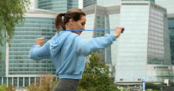 ジャンプロープを使用して女性は屋外に収まるように。ジャンプロープ演習を行う戦闘機 — ストック動画