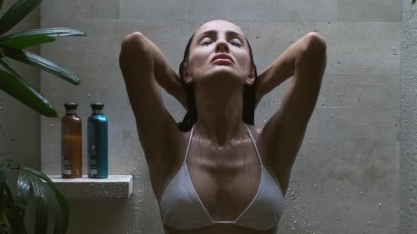 Schöne Frau mit nassen Haaren genießt die Dusche und schaut in den Himmel — Stockvideo
