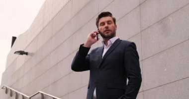 Gülümseyen işadamı cep telefonundan konuşuyor. Takım elbiseli patron.
