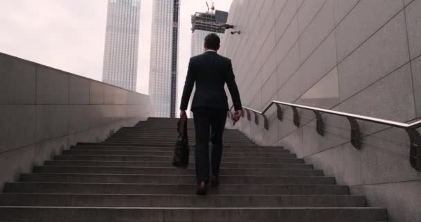 사업가가 계단을 오르고 있어. 카메라가 위로 움직입니다. 성공으로 가는 계단을 오르는 일 — 비디오