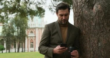 Takım elbiseli bir erkek randevuda bir kızı bekliyor. Tanıdık, kahve, köprü.