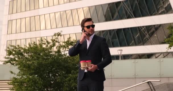 Un uomo in giacca e cravatta che parla al cellulare. con caffè New York — Video Stock