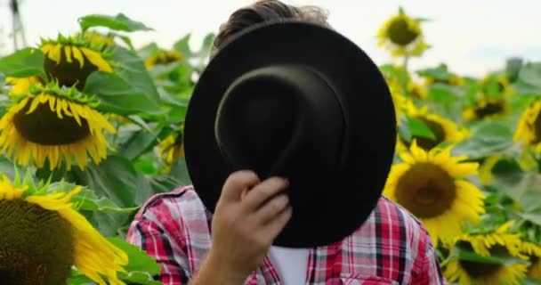 Фермер-австралієць носить ковбойський капелюх, соняшник. Дивлячись на камеру. — стокове відео