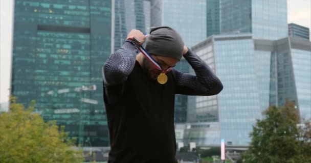 Atleta de pie con tres medallas de oro colgando de una cinta roja blanca y azul — Vídeo de stock