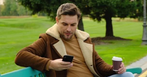 Een man in een jasje en een coltrui communiceert met een meisje op een dating site — Stockvideo