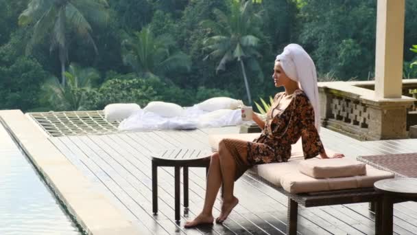 Chica elegante en un albornoz tiene desayuno en villa tropical por la mañana Bali — Vídeo de stock