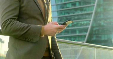 Şehirde cep telefonu kullanan ve kahve içen kendine güvenen genç bir işadamı.