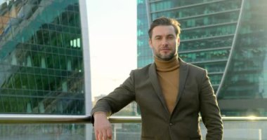 Takım elbiseli ve balıkçı yakalı cesur iş adamı kameraya bakıyor.