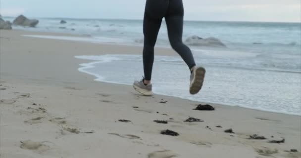Koşan kadın koşucu, sahilde egzersiz yaparken koşuyor. — Stok video