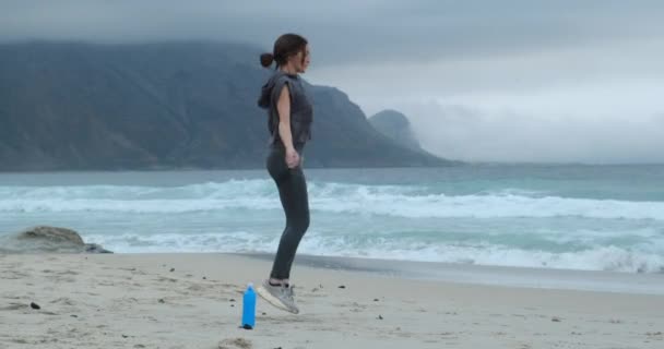 Pewna siebie młoda kobieta skacząca na linie. poranny trening nad oceanem — Wideo stockowe