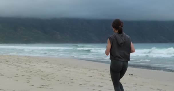 Back view Correr corredor feminino correndo durante o treino ao ar livre na praia., ajuste — Vídeo de Stock